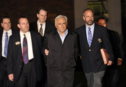 Giám đốc IMF Dominique Strauss-Kahn (giữa) được cảnh sát dẫn ra khỏi đồn cảnh sát ở New York, sau khi bị truy tố về tội âm mưu cưỡng hiếp một nữ hầu phòng ở New York, hôm 15/5. Giám đốc IMF Dominique Strauss-Kahn (giữa) được cảnh sát dẫn ra khỏi đồn cảnh sát ở New York, sau khi bị truy tố về tội âm mưu cưỡng hiếp một nữ hầu phòng ở New York, hôm 15/5.