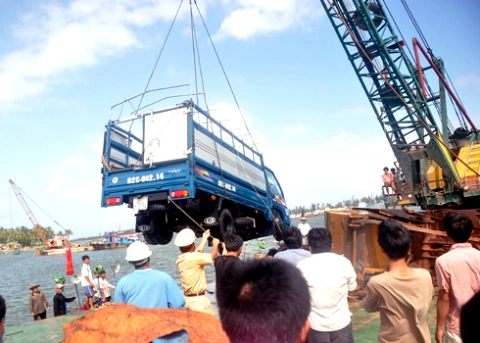 Lực lượng cứu hộ trục vớt chiếc ô tô tải chở đầy củi từ dưới sông Trường Giang lên sà lan- nguyên nhân chính gây ra vụ chìm phà vào sáng 21/11 trên sông Trường Giang. Ảnh: Trí Tín