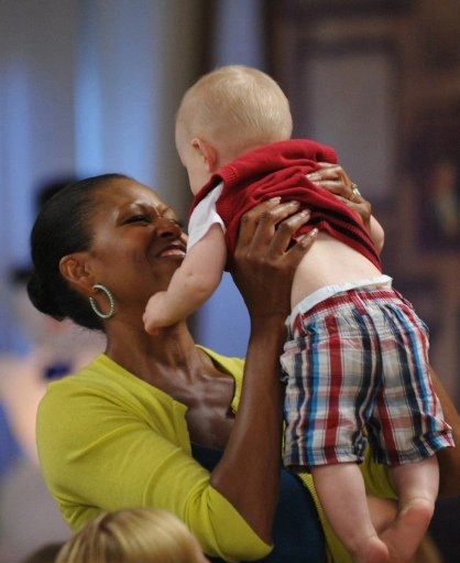 US President Barack Obama chats with a family while greeting military personnel and their families at a mess hall at Marine Base Hawaii at Kaneohe Bay on Christmas Day, December 25, 2011. Obama greeted base personnel while vacationing at a rental home nearby