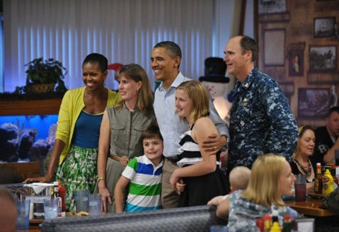 US President Barack Obama poses with a military family while greeting service members at the mess hall at Marine Base Hawaii at Kaneohe Bay on Christmas Day, December 25, 2011. Obama greeted base personnel while vacationing at a rental home nearby US President Barack Obama poses with a military family while greeting service members at the mess hall at Marine Base Hawaii at Kaneohe Bay on Christmas Day, December 25, 2011. Obama greeted base personnel while vacationing at a rental home nearby