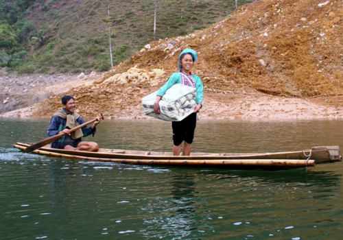 Một người phụ nữ dân tộc Thái vui mừng khi mua được chăn ấm cho con.