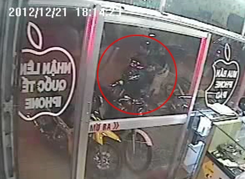 Tên trộm lợi dụng cửa hàng đang đông khách đã lẻn vào bẻ khóa trộm xe máy. Ảnh chụp từ clip