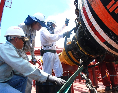 Các chuyên gia, kỹ sư đang đấu nối ống bơm dầu thô từ tàu trọng tải tải lớn neo đậu ngoài vịnh Việt Thanh vào bồn, bể chứa nhà máy lọc dầu Dung Quất chế biển sản phẩm xăng, dầu. Ảnh: Trí Tín.