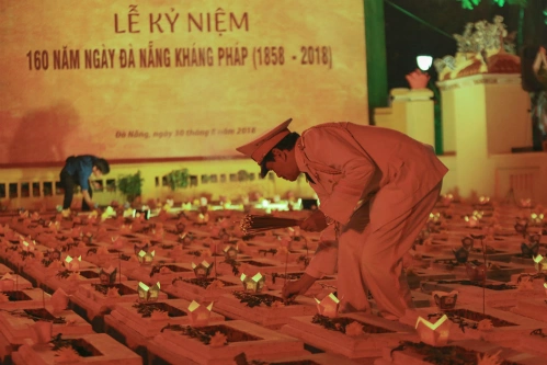 Người dân thắp hương, đặt hoa đăng lên mộ các nghĩa sỹ hi sinh trong những ngày đầu kháng Pháp tại nghĩa trũng Hoà Vang tối 30/8. Ảnh: Nguyễn Đông.