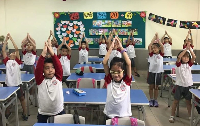 Học sinh trường Tiểu học Lê Quý Đôn tập thể dục trong lớp học. Ảnh: Thanh Hằng