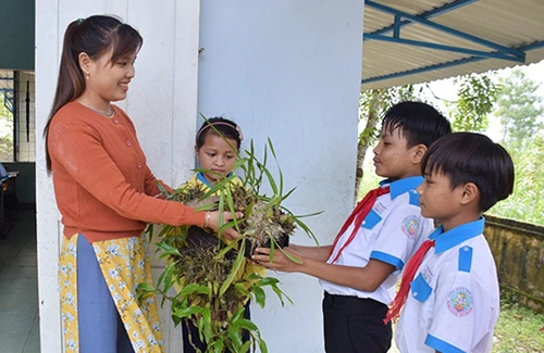 Cô Võ Thị Huyền Sinh nhận quà của học sinh tặng ngoài cửa lớp. Ảnh: Sơn Thủy.