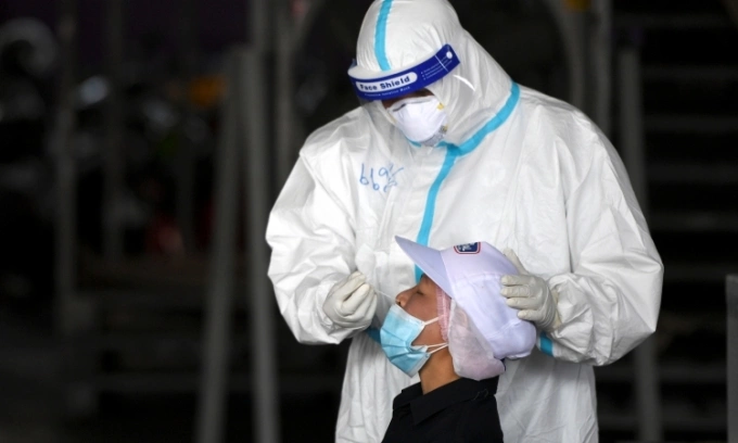 Nhân viên y tế lấy mẫu xét nghiệm cho người dân ở tỉnh Samut Sakhon, Thái Lan, hôm 27/1. Ảnh: Reuters.