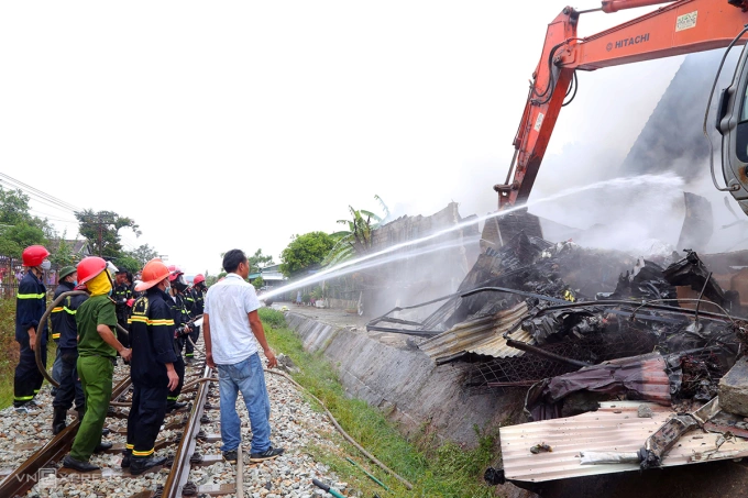 Trưa 12/6, cảnh sát dùng cần cẩu kéo sập nhà kho để khống chế ngọn lửa. Ảnh: Việt Anh
