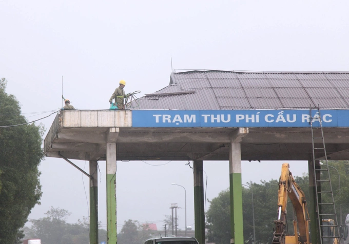 Công nhân tháo dỡ mái che trạm thu phí Cầu Rác, ngày 18/11. Ảnh: Hùng Lê