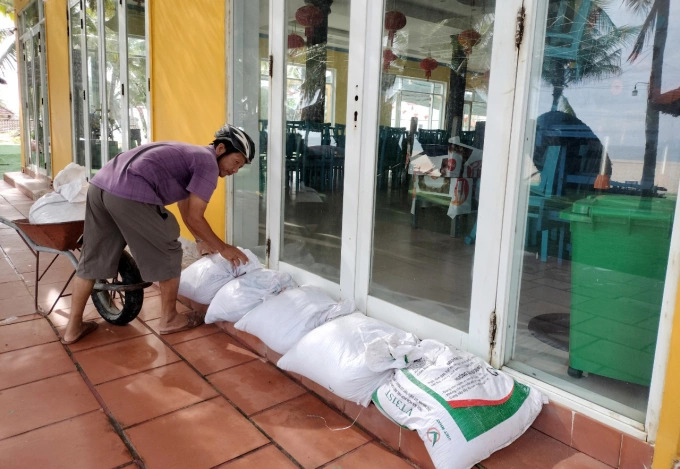 Người dân TP Hội An dùng bao cát chèn cửa kính nhà hàng ven biển cửa Đại. Ảnh: Đắc Thành