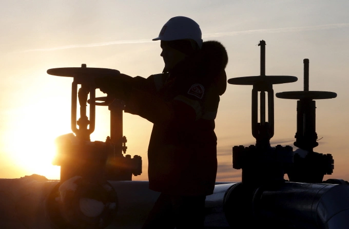 Công nhân kiểm tra đường ống dẫn dầu của công ty Lukoil tại giếng dầu Imilorskoye ở ngoại ô thành phố Kogalym, Nga hôm 25/1/2016. Ảnh: Reuters.