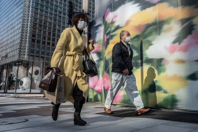Người đi bộ ở thủ đô Tokyo, Nhật Bản, ngày 20/2. Ảnh: AFP.