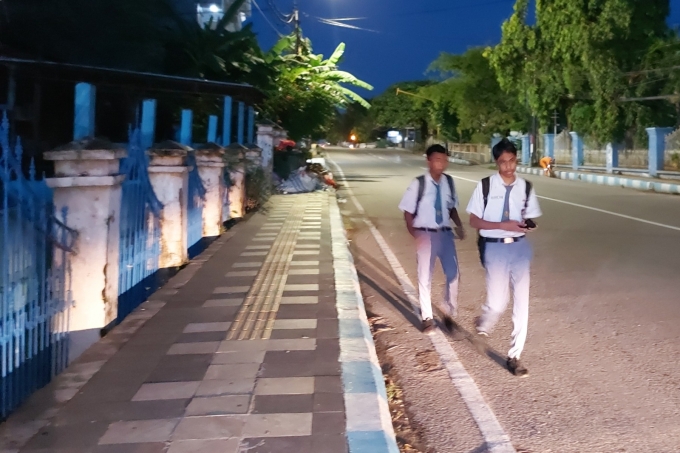 Học sinh trung học phổ thông ở Kupan đi bộ đến trường vào rạng sáng, ngày 6/3. Ảnh: AFP.