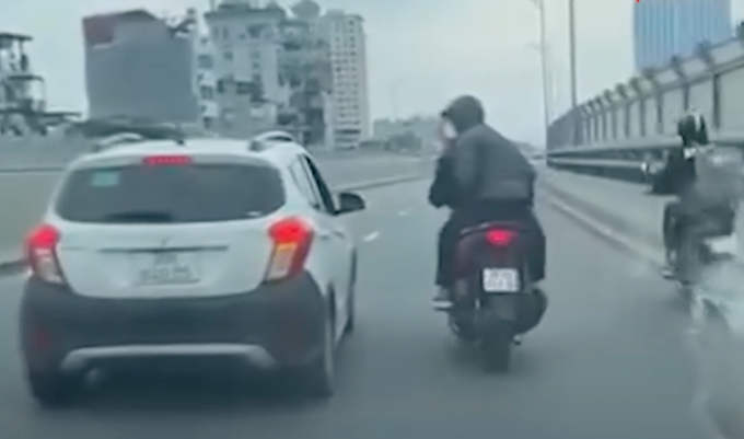 Hiệp và Thịnh chở nhau trên xe máy, chặn đầu ôtô và ẩu đả. Ảnh: Cắt từ clip