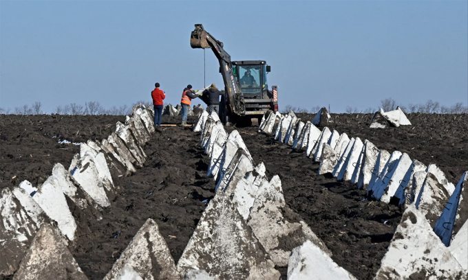 Công nhân Ukraine lắp chướng ngại vật răng rồng ở tỉnh Kharkov ngày 18/3. Ảnh: AFP