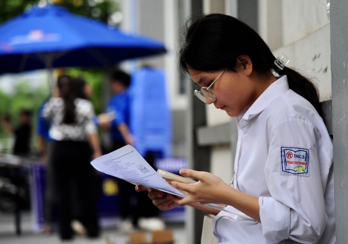 Thí sinh so đáp án sau buổi thi tiếng Anh tại trường THCS Yên Hoà, quận Cầu Giấy. Ảnh: Duy Anh