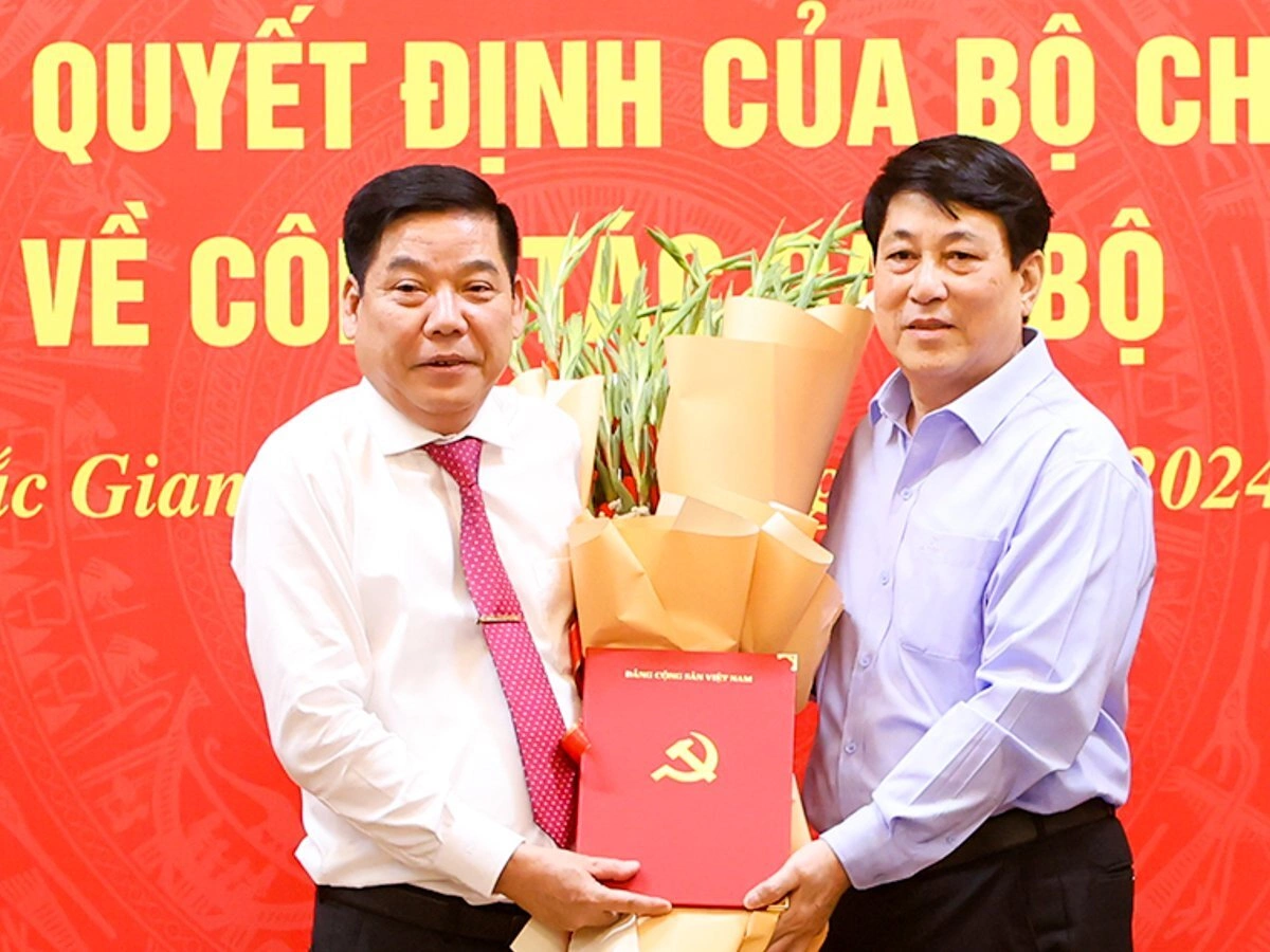 Thường trực Ban Bí thư Lương Cường (phải) trao quyết định và tặng hoa cho tân Bí thư Nguyễn Văn Gấu. Ảnh: Bacgiang.gov