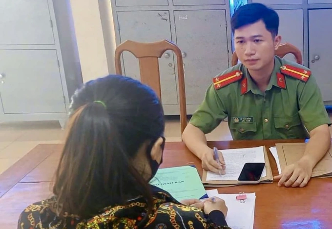 Cảnh sát làm việc với một phụ nữ đăng tin sai sự thật. Ảnh: Công an cung cấp
