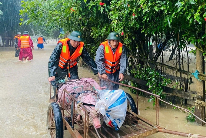Bộ đội giúp người dân Quảng Bình sơ tán tài sản. Ảnh: Vạn An