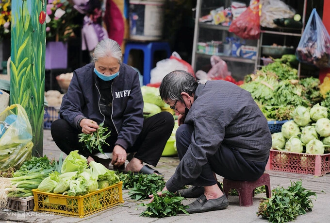 Cặp vợ chồng mưu sinh bằng sạp rau củ ở chợ Thành Công (Hà Nội). Ảnh: Ngọc Thành