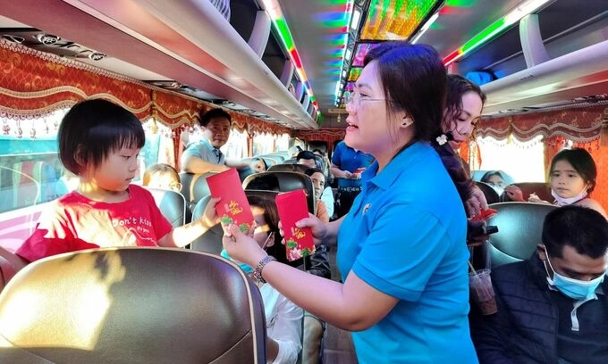 Cán bộ công đoàn ở TP HCM lì xì cho con công nhân trên chuyến xe về quê đón Tết năm trước. Ảnh:An Phương