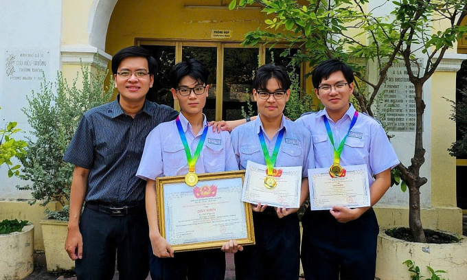 Phong (thứ nhất từ phải sang), cùng thầy giáo và bạn, dịp giành giải nhất thi học sinh giỏi môn Tiếng Anh quốc gia, tháng 1/2025. Ảnh: THPT chuyên Trần Đại Nghĩa