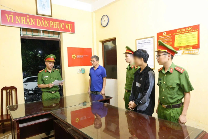 Công an đọc lệnh tạm giữ với nam thanh niên (áo khoác đen, còng tay). Ảnh: Công an Nam Định