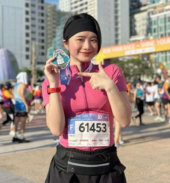 Runner Thái Vy check-in cùng huy chương khắc hình tháp bà Ponagar - biểu tượng của thành phố Nha Trang, tại mùa giải VnExpress Marathon 2024. Ảnh: VnExpress Marathon