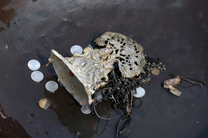 Tiền xu, đồ vật có giá trị thu thập được ở sông Yamuna, New Delhi, ngày 26/6. Ảnh: Reuters