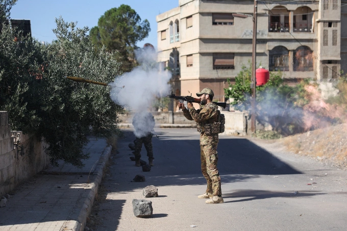 Một chiến binh Syria khai hỏa vũ khí vác vai giữa giao tranh tại Sweida, ngày 16/7. Ảnh: AFP
