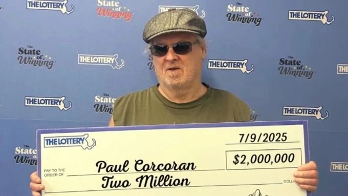 Ông Paul Corcoran cầm tấm bảng tiền thưởng 2 triệu USD tại trụ sở Xổ số bang Massachusetts. Ảnh: CNN
