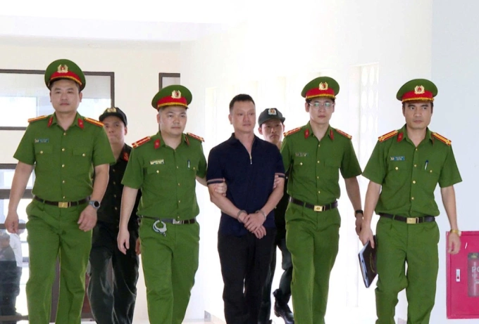 Cảnh sát áp giải trùm giang hồ Vi Ngộ. Ảnh: Lam Sơn