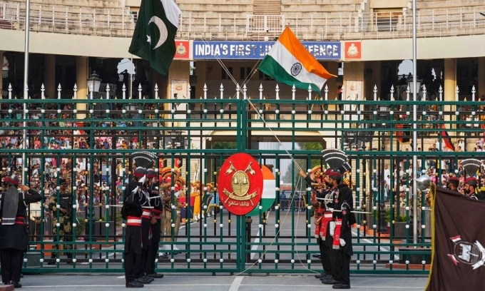 Lực lượng biên phòng Pakistan, mặc đồ đen, và Lực lượng An ninh Biên giới Ấn Độ, mặc đồ kaki, trong một buổi lễ hạ cờ tại cửa khẩu biên giới Wagah. Ảnh: AP