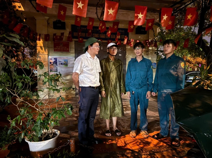 Chủ tịch UBND phường Giảng Võ Cồ Như Dũng (áo trắng) cùng lực lượng dân quân tự về trao đổi phương án chốt trực, phối hợp cùng lực lượng công an bảo đảm an ninh, an toàn khu chung cư khi người dân di dời tạm. Ảnh: Hoàng Phong