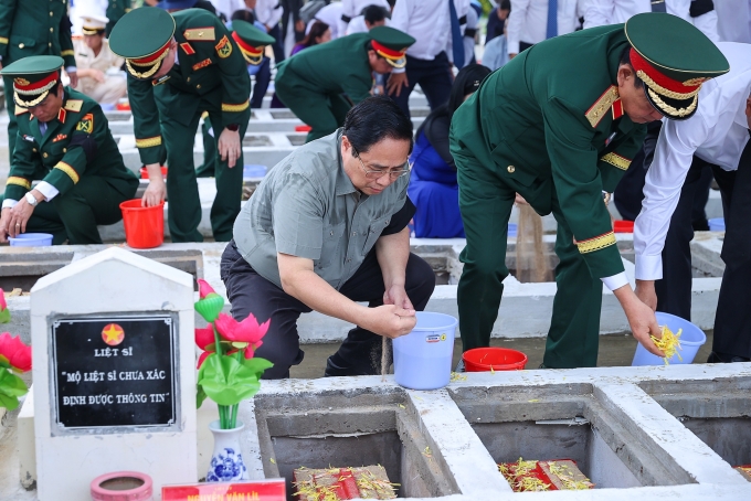 Thủ tướng Phạm Minh Chính cùng đoàn công tác thực hiện nghi lễ an táng hài cốt liệt sĩ tại Nghĩa trang liệt sĩ Dốc Bà Đắc. Ảnh: VGP/Nhật Bắc