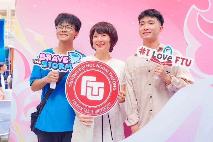 Hiệu trưởng Phạm Thu Hương (giữa) cùng các thí sinh tại quầy thông tin của trường Đại học Ngoại thương, ở Hà Nội, hôm 19/7. Ảnh: FTU Times