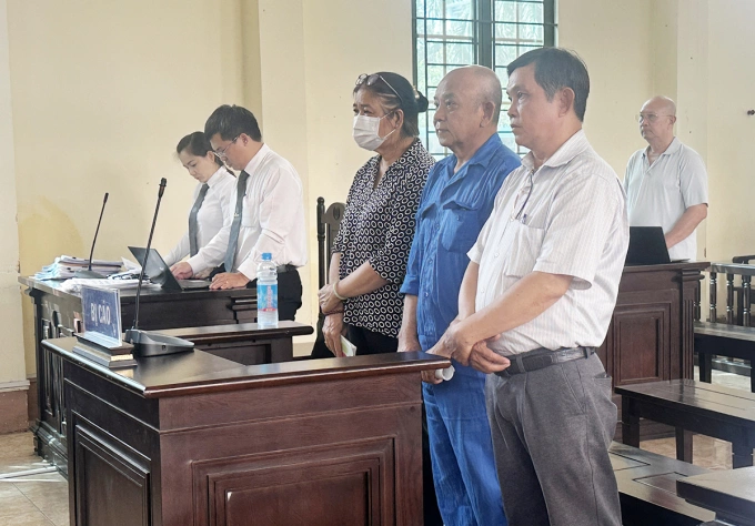 Ông Trần Quốc Tân (áo xanh, đứng giữa) cùng em trai và vợ tại toà. Ảnh: Quốc Thắng
