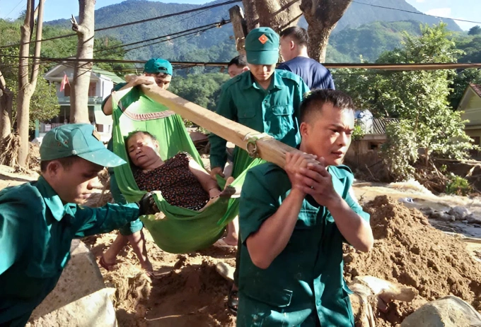 Vi Văn Hiếu (góc phải) tham gia đưa bệnh nhân tại vùng lũ xã Tà Cạ đi cấp cứu hồi tháng 10/2022. Ảnh: Nhân vật cung cấp