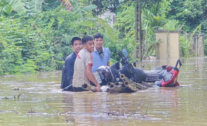 Người dân sống bên quốc lộ 7 đưa tài sản lên chỗ cao tránh trú, ngày 23/7. Ảnh: Hùng Lê