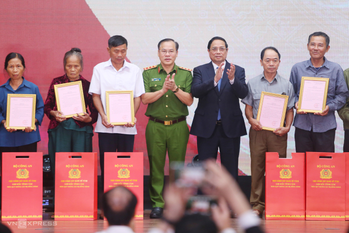 Thủ tướng Phạm Minh Chính và thứ trưởng Công an Nguyễn Văn Long trao chứng nhận, quà cho các gia đình. Ảnh: Phạm Dự