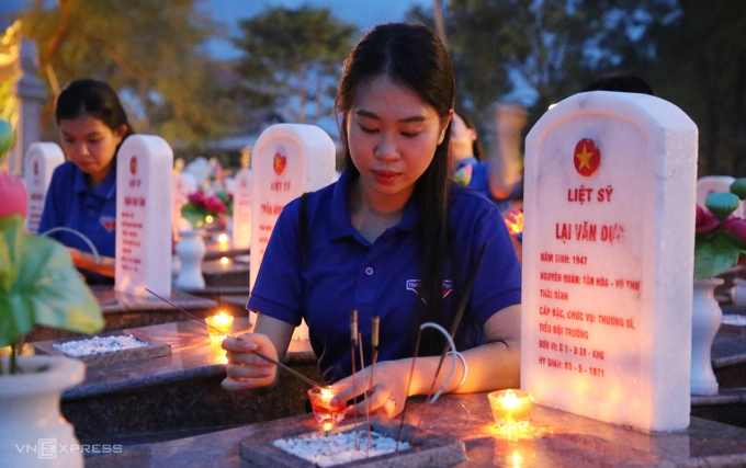 Đoàn thanh niên tỉnh Quảng Trị thắp nến những phần một liệt sĩ. Ảnh: Đắc Thành