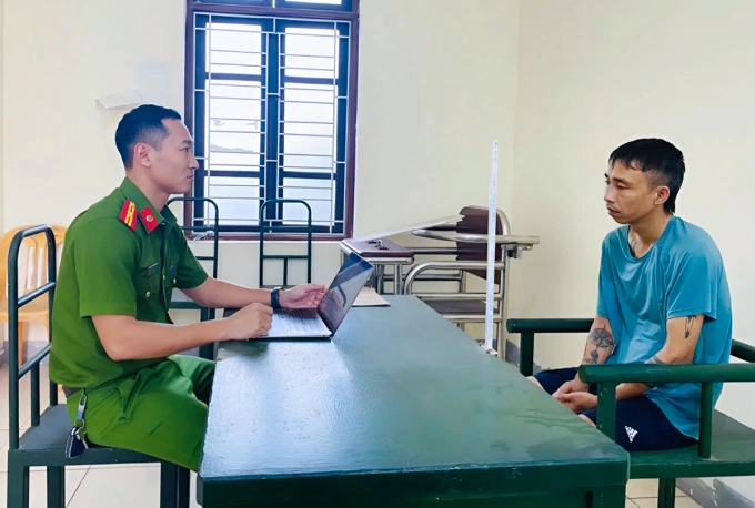Lê Ngọc Thành, góc phải, làm việc với cảnh sát. Ảnh: Công an cung cấp