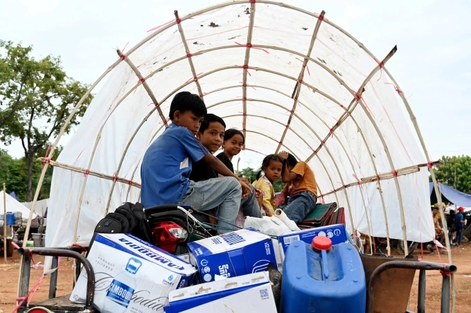 Trẻ em phải sơ tán ngồi trên thùng xe tại một ngôi chùa ở tỉnh Oddar Meanchey, Campuchia, ngày 26/7. Ảnh: AFP