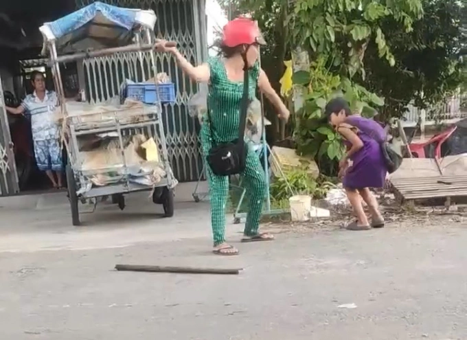 Cảnh bà Nguyễn Thị Đời cầm cây đánh cháu trai 13 tuổi, chiều 24/7. Ảnh: Cắt từ video của người dân