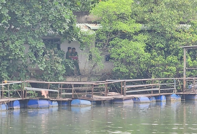 Cảnh sát khám nghiệm hiện trường tại ngôi nhà bị cháy, trưa 29/7. Ảnh: Đình Văn