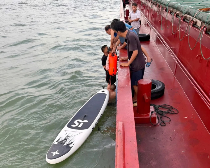 Lực lượng cứu hộ đưa bé gái từ thuyền kayak lên tàu, sáng 31/7. Ảnh: Đức Long