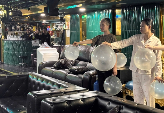 Các nhân viên cung cấp bóng cười cho khách trong quán bar. Ảnh: Công an cung cấp