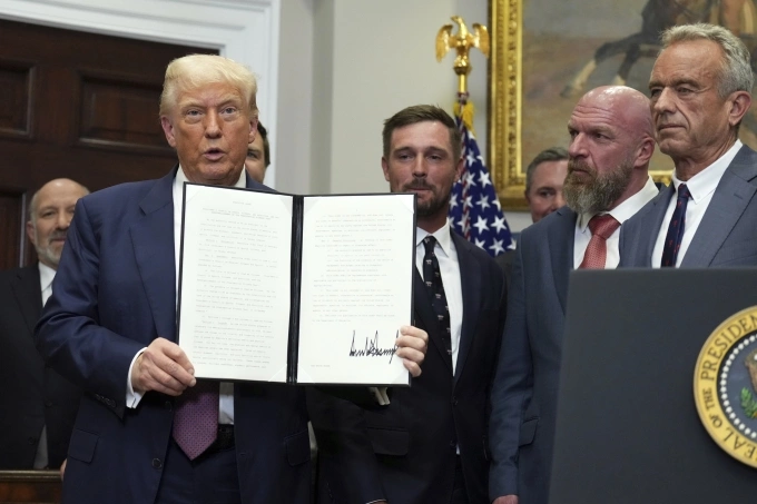 Ông Trump giơ sắc lệnh đã ký tại Phòng Roosevelt ở Nhà Trắng ngày 31/7. Ảnh: AP