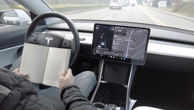 Tài xê đọc sách trong khi chế độ tự lái của Tesla đang vận hành. Ảnh: Euro Weekly