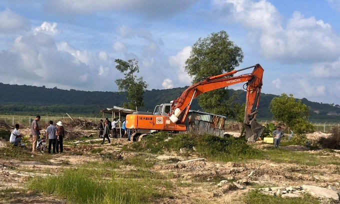 Chính quyền huy động phương tiện tháo dỡ nhà lấn chiếm đất để xây dựng hàng rào ở sân bay. Ảnh: Dương Đông